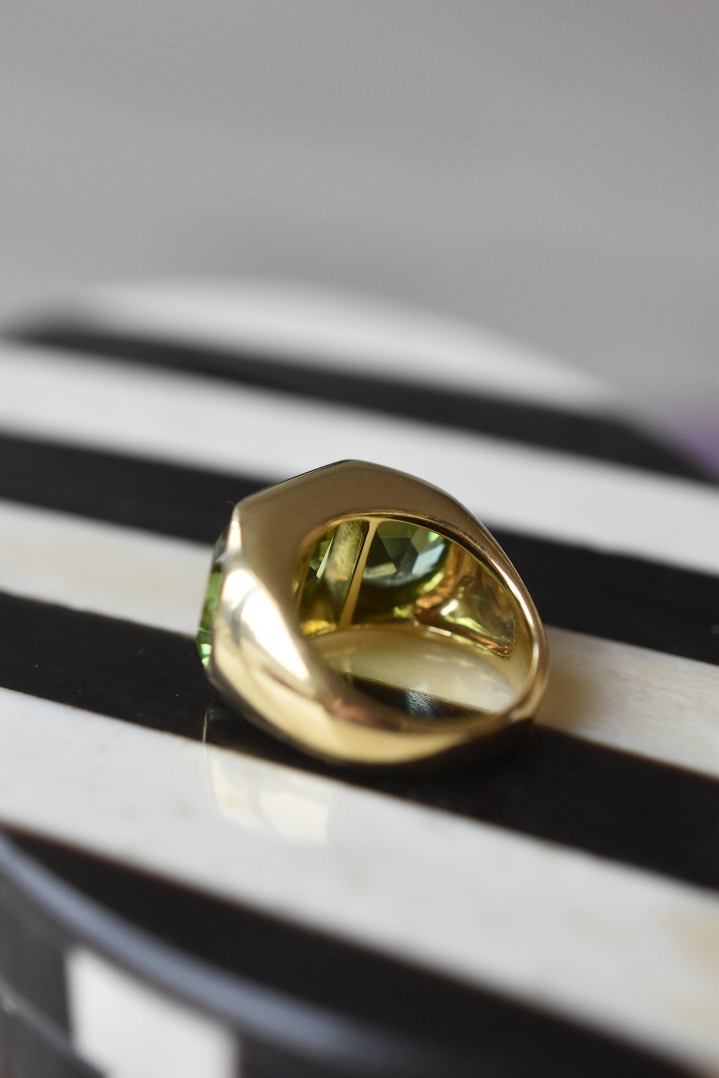 A Large Channel-set Peridot and 18K Gold Trilogy Ring