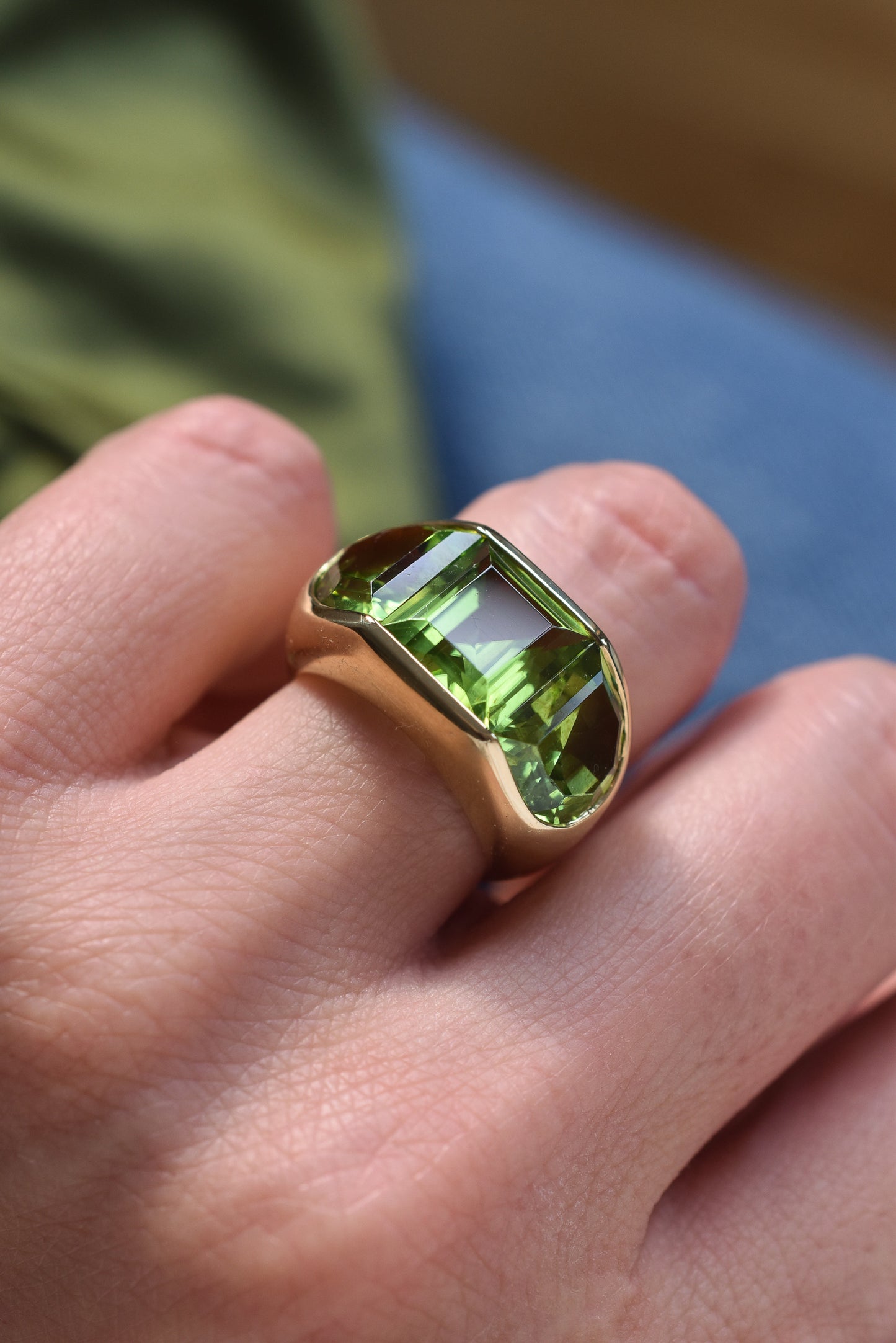 A Large Channel-set Peridot and 18K Gold Trilogy Ring