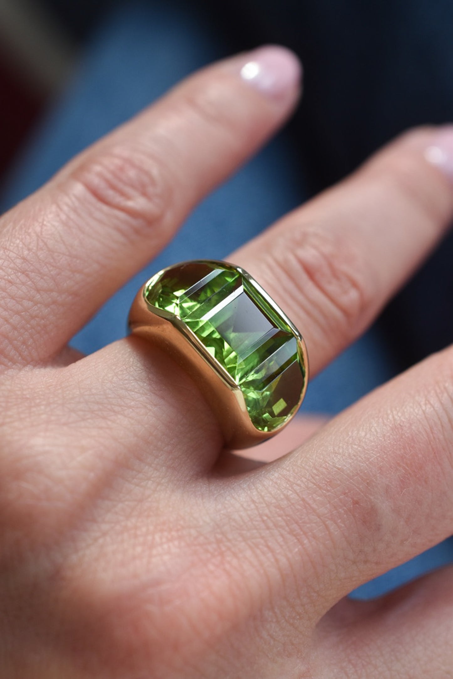 A Large Channel-set Peridot and 18K Gold Trilogy Ring
