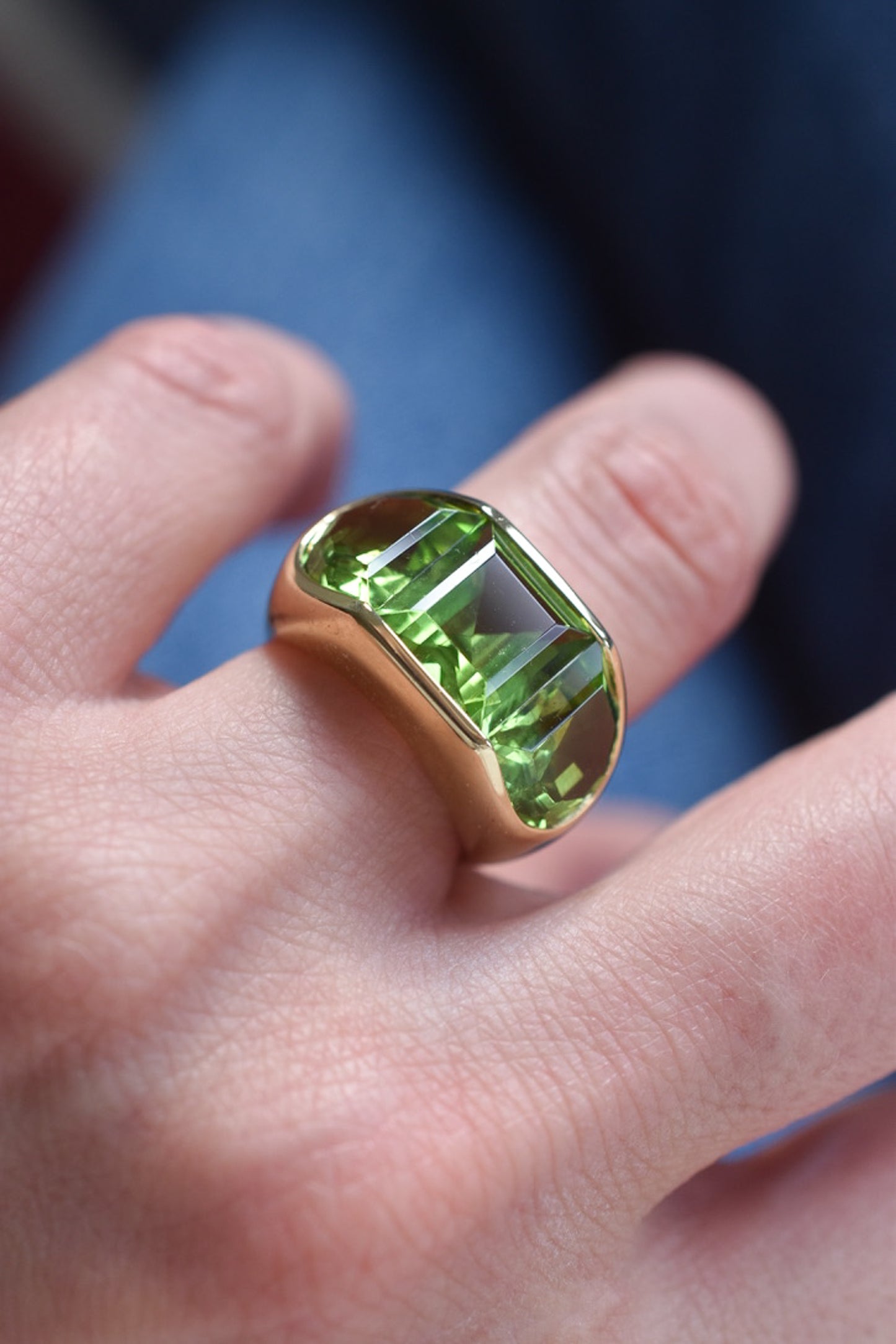 A Large Channel-set Peridot and 18K Gold Trilogy Ring