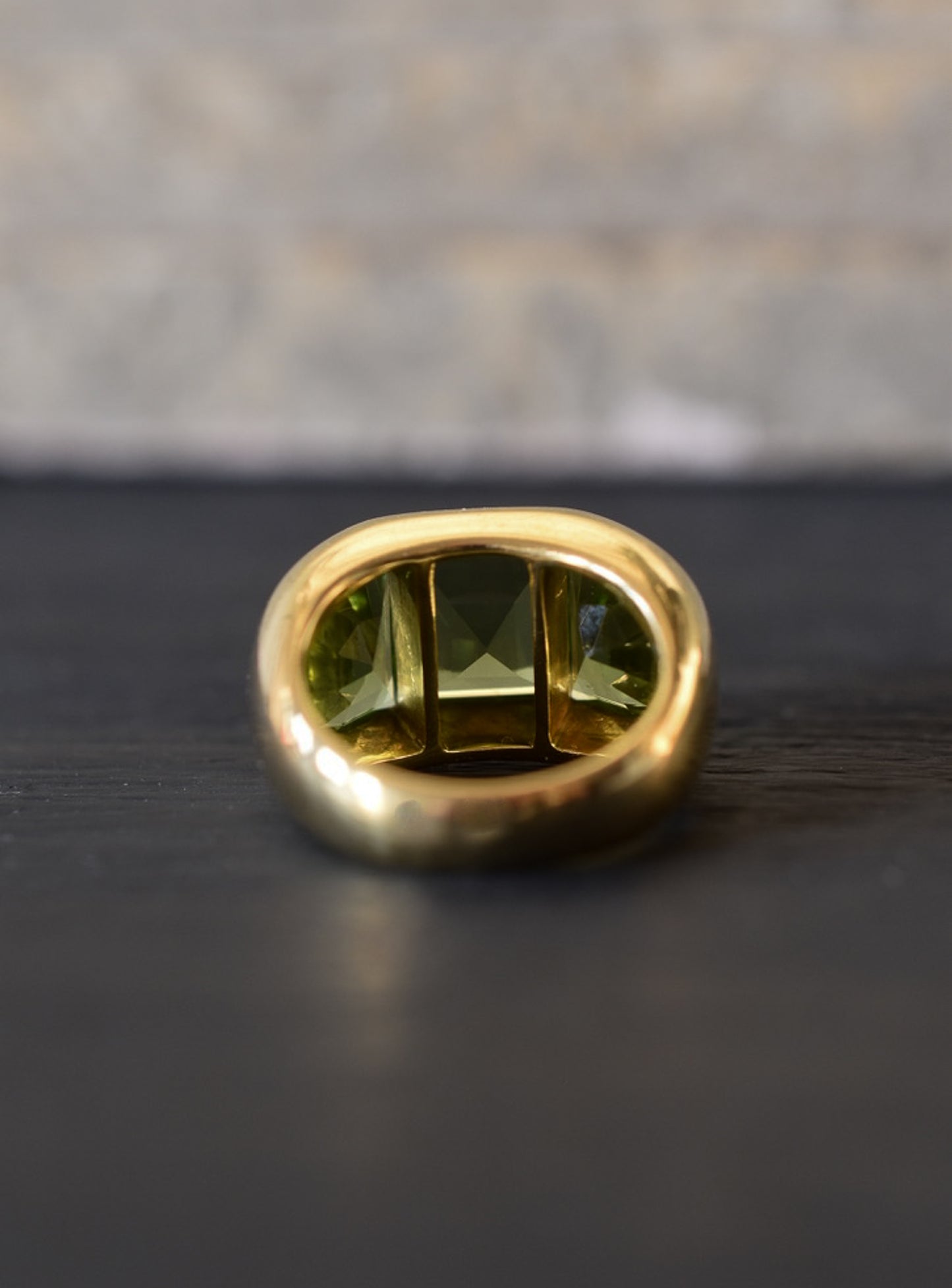 A Large Channel-set Peridot and 18K Gold Trilogy Ring